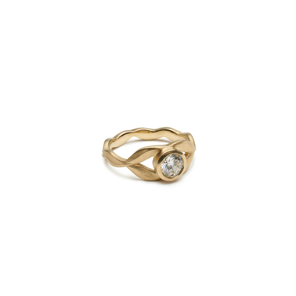 Gold or platinum ring with willow leaf design wrapping a solitaire stone, shown with 5 mm Moissanite.