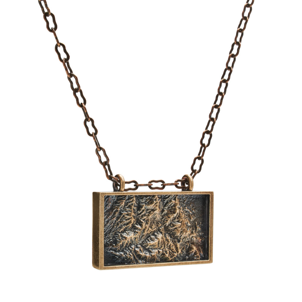 Oxidized bronze Titus Canyon pendant in a rectangular frame on a matching bronze chain.