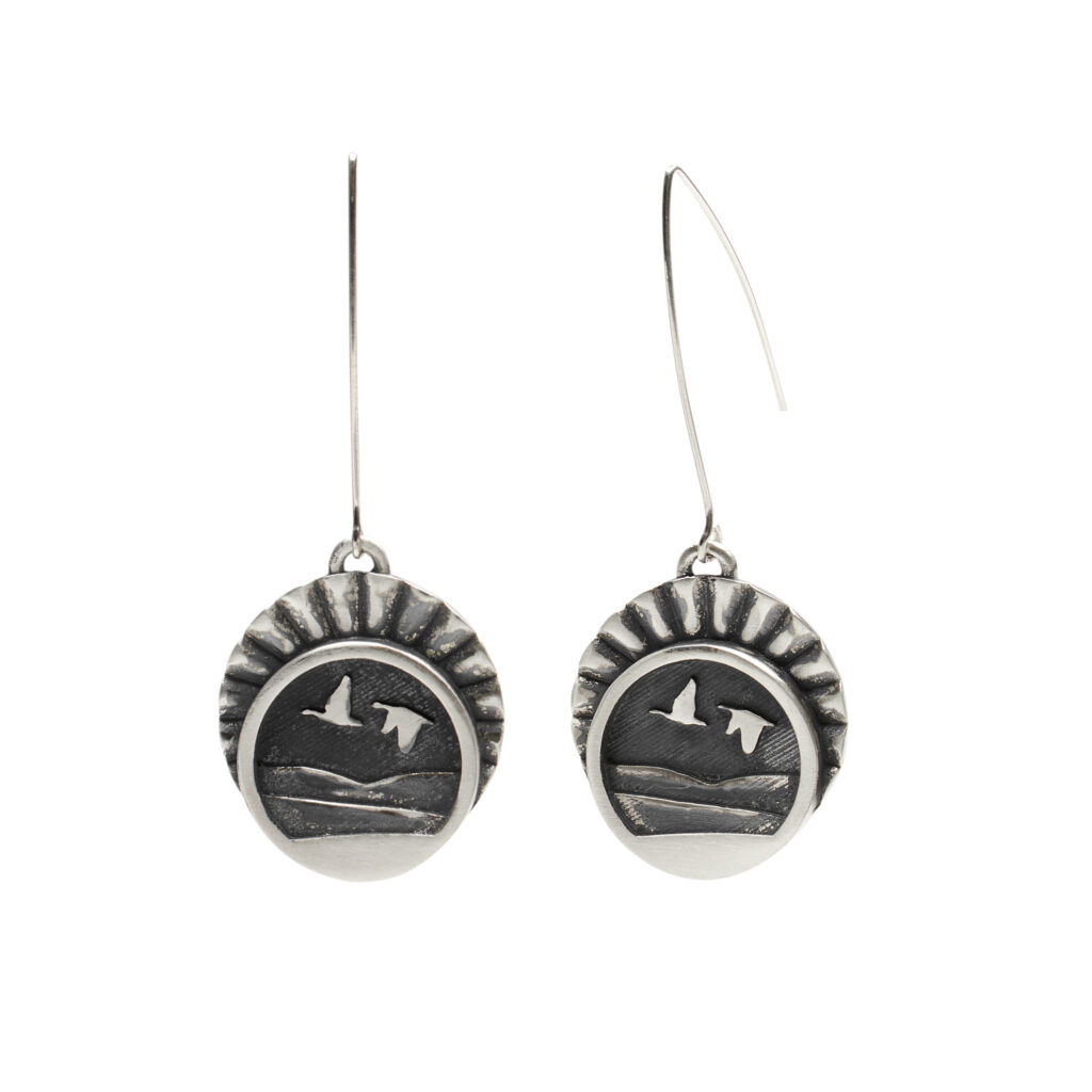 Oxidized sterling silver earrings with birds flying over Vermont mountains, capturing motion and seasonal change.