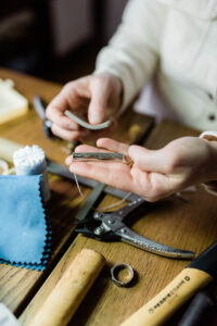Vermont jewelry artist crafting custom map jewelry at the workbench